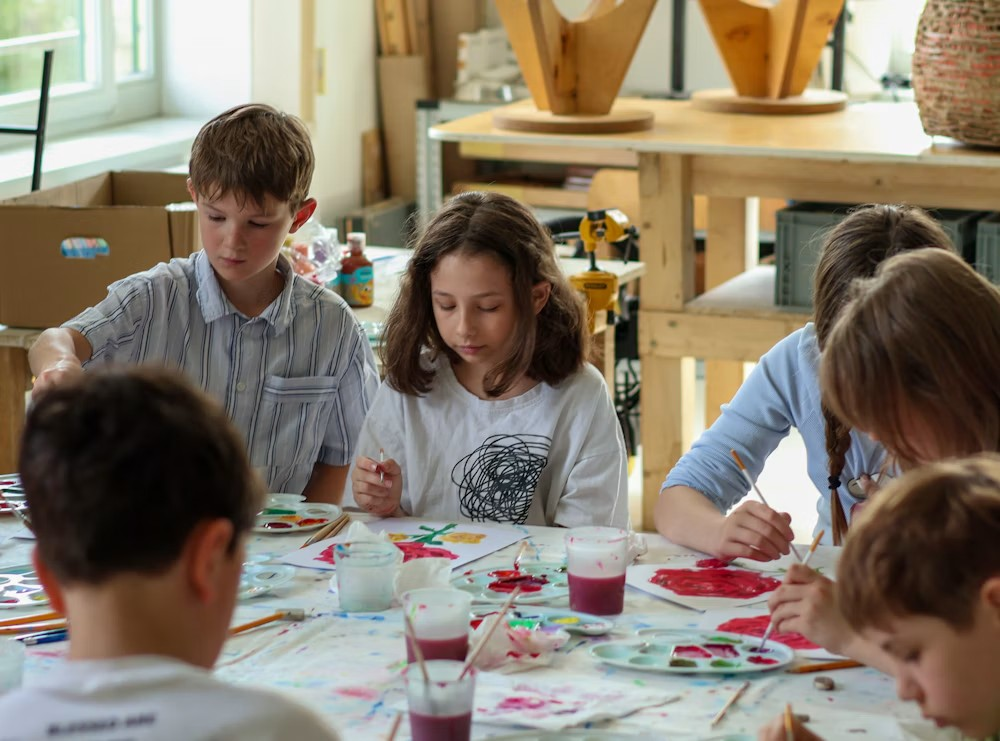 Children painting together at a table